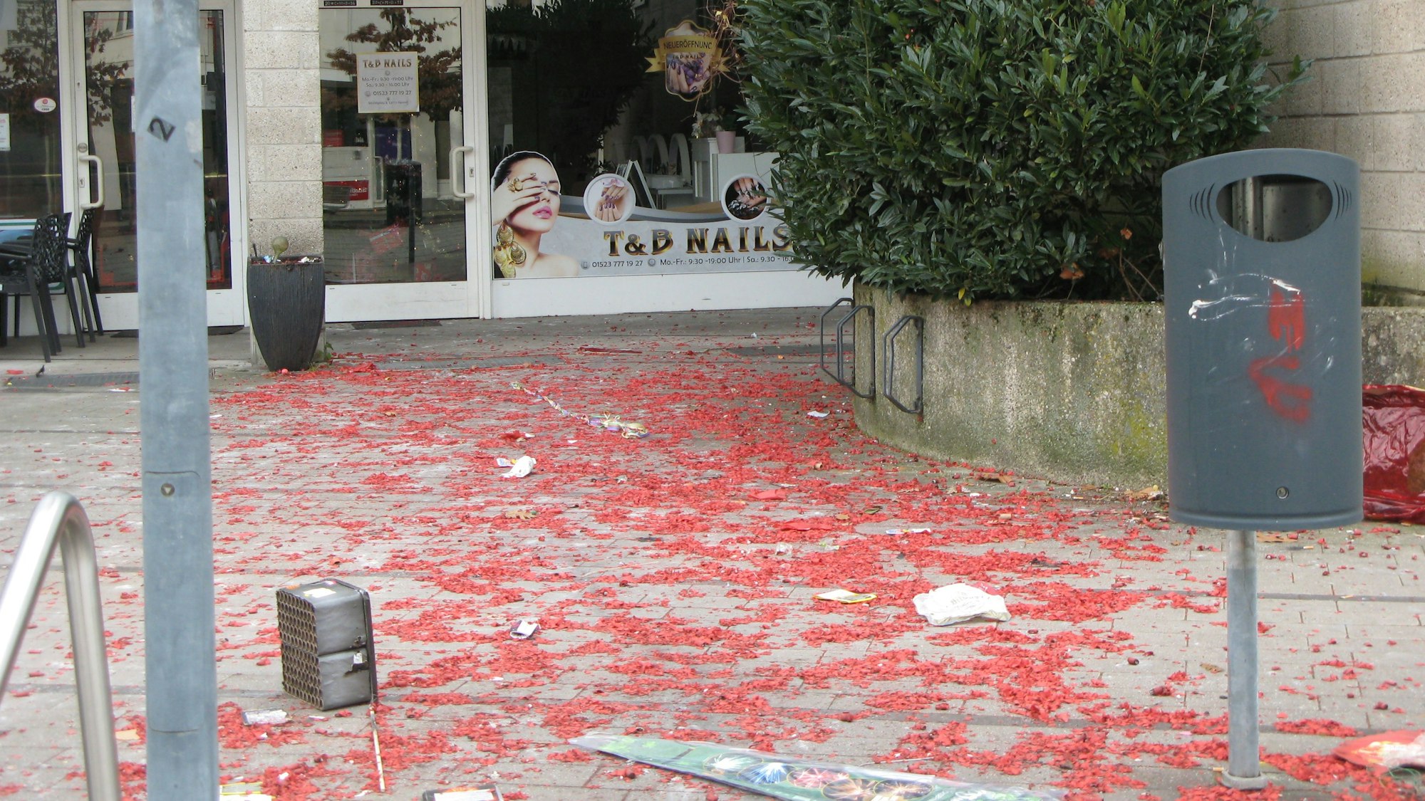 Die Fläche vor einem Schaufenster mit ist mit Tausenden von kleinen, roten Papierschnipseln übersät.