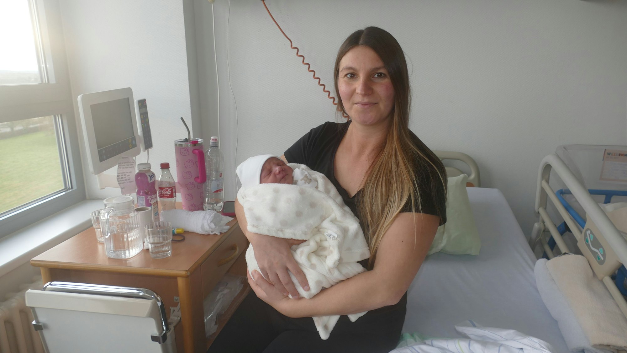 Eine Mutter hält ihr Neugeborenes im Arm.