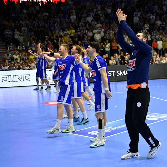Die Handballer des VfL Gummersbach jubeln nach einem Spiel mit den Fans im Fanblock.