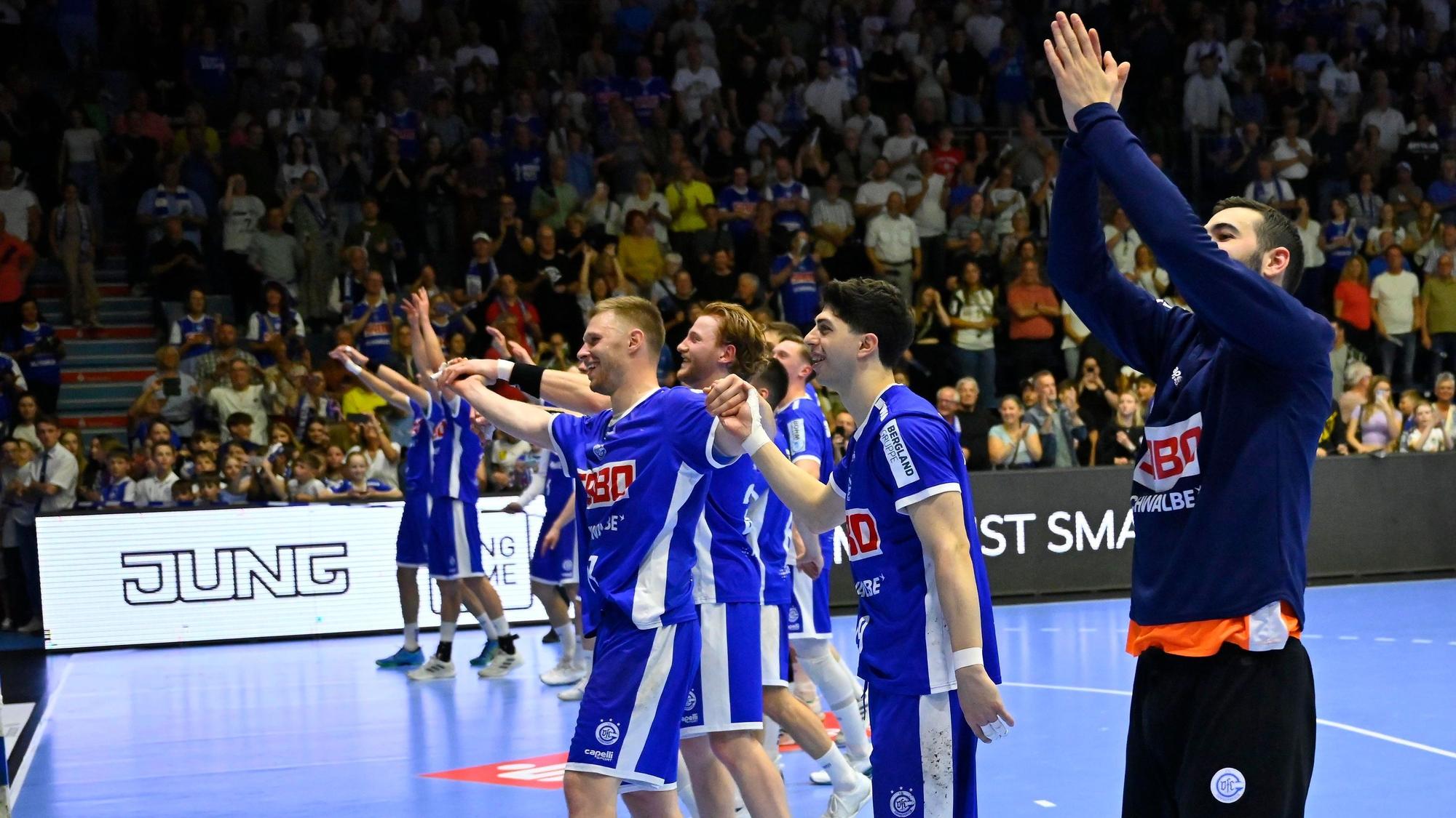 Die Handballer des VfL Gummersbach jubeln nach einem Spiel mit den Fans im Fanblock.