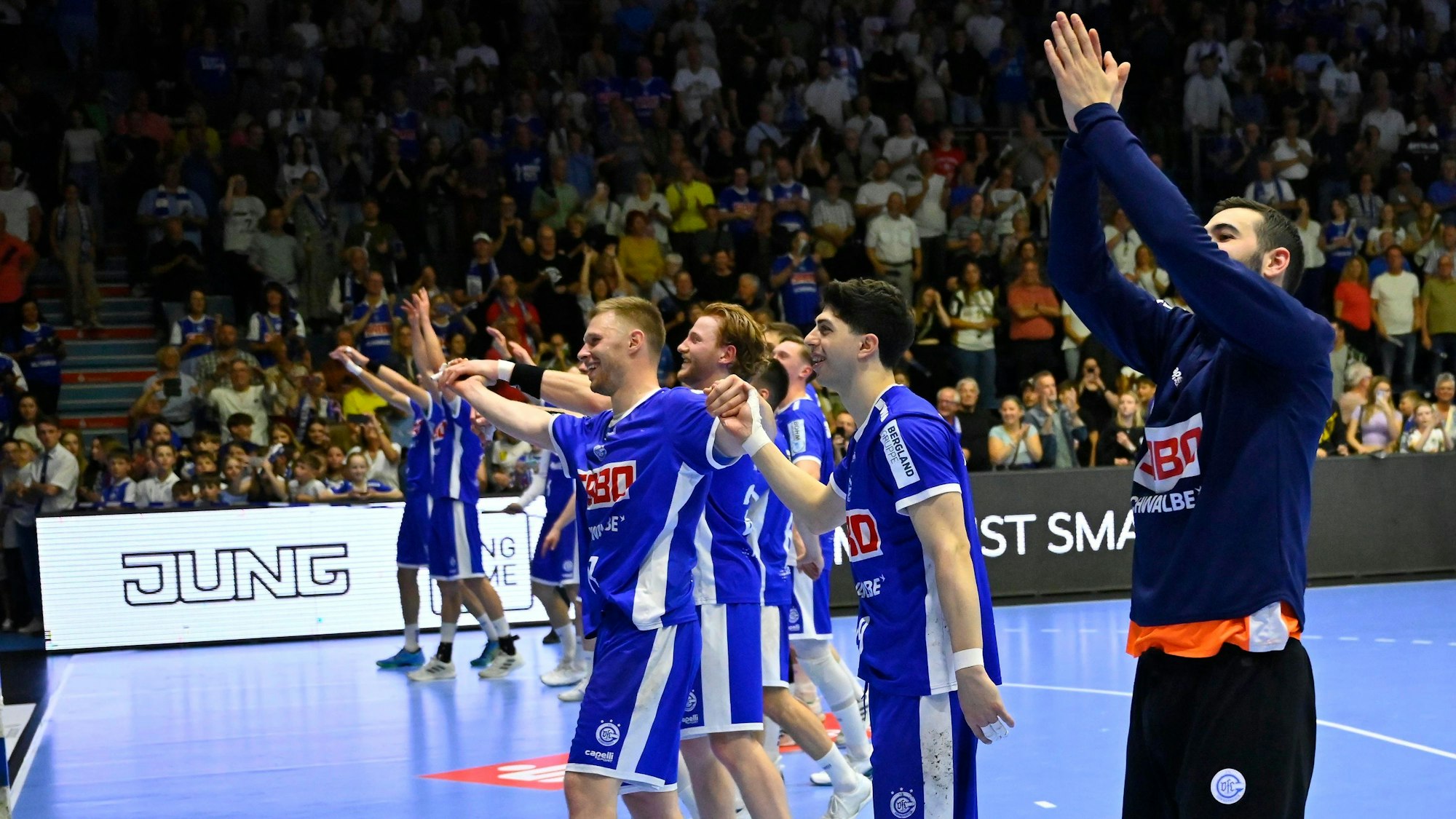 Die Handballer des VfL Gummersbach jubeln nach einem Spiel mit den Fans im Fanblock.