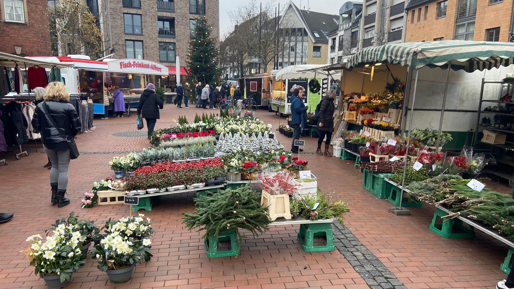 Auf dem Bild sind Marktstände in Pulheim mit Blumen und Kleidung zu sehen.