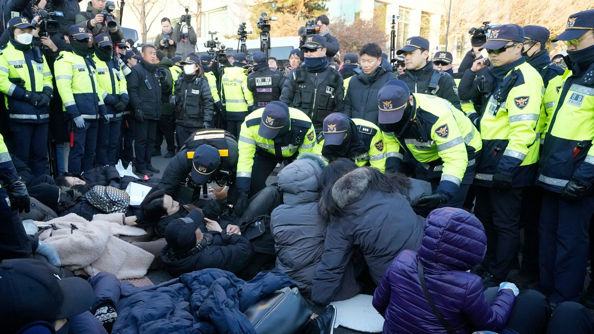 Polizeibeamte tragen Anhänger des angeklagten südkoreanischen Präsidenten Yoon Suk Yeol in der Nähe der Präsidentenresidenz weg.
