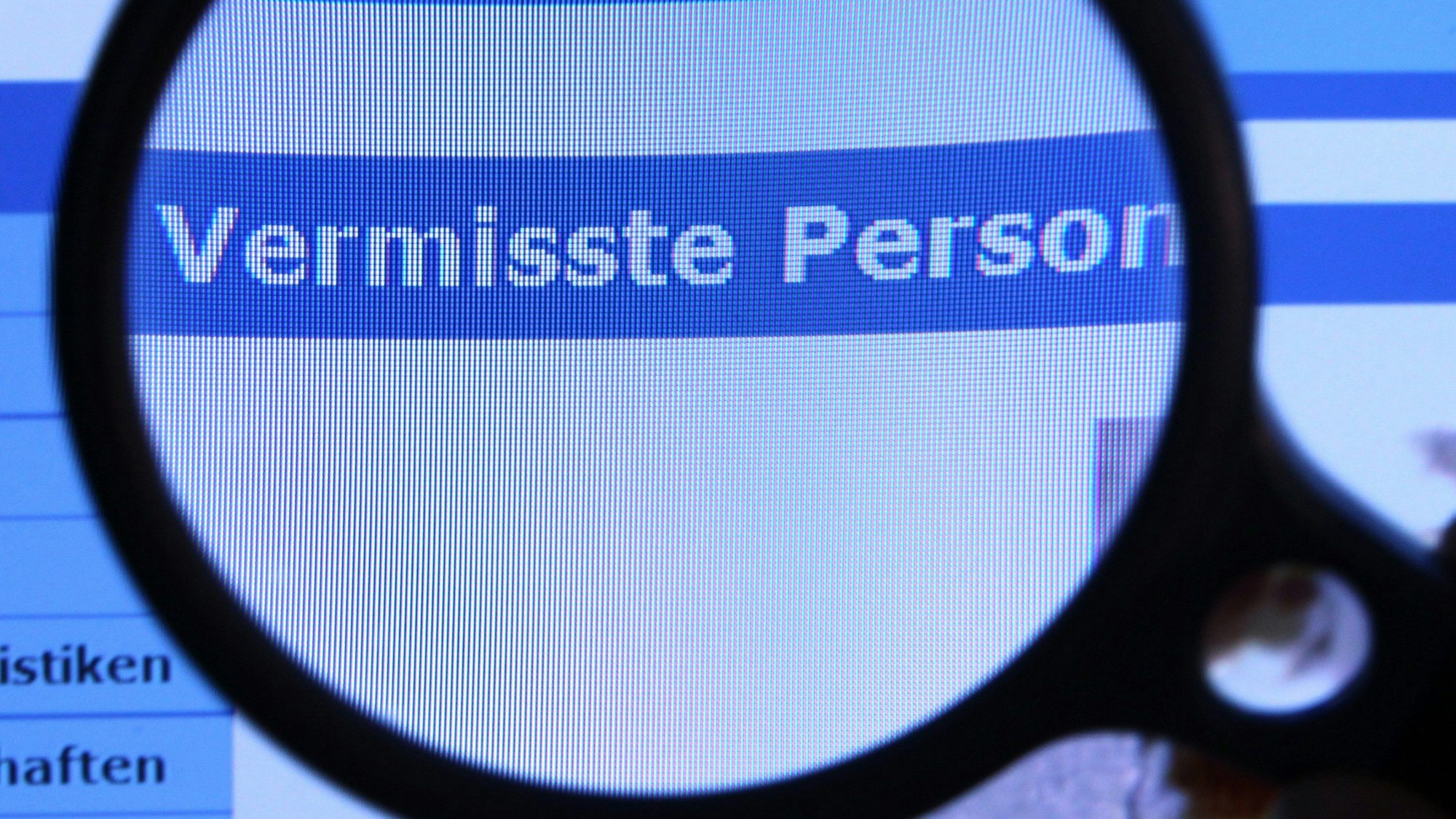 Hinter einer Lupe ist der Schriftzug «Vermisste Person» zu sehen.