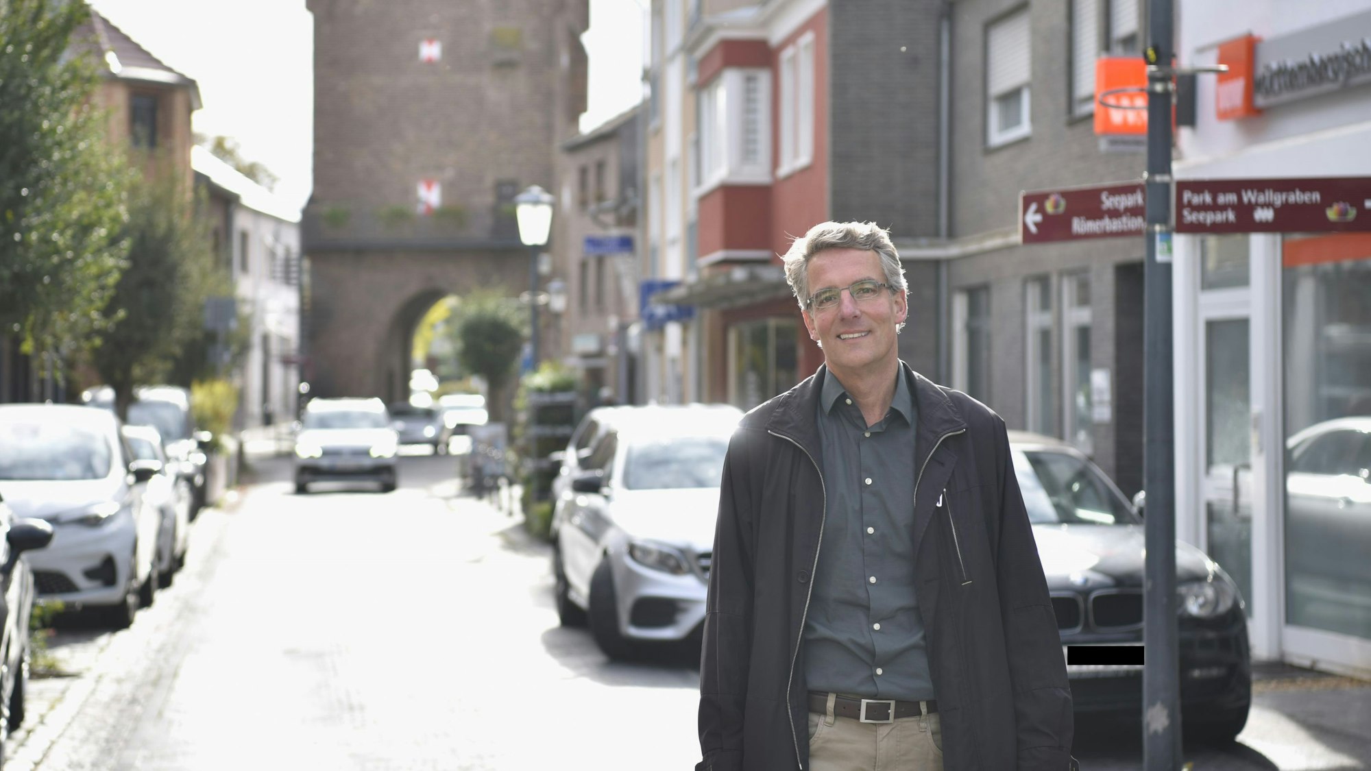 Stadtplaner Christoph Hartmann steht auf der Münsterstraße, im Hintergrund ist ein Stadttor zu sehen.