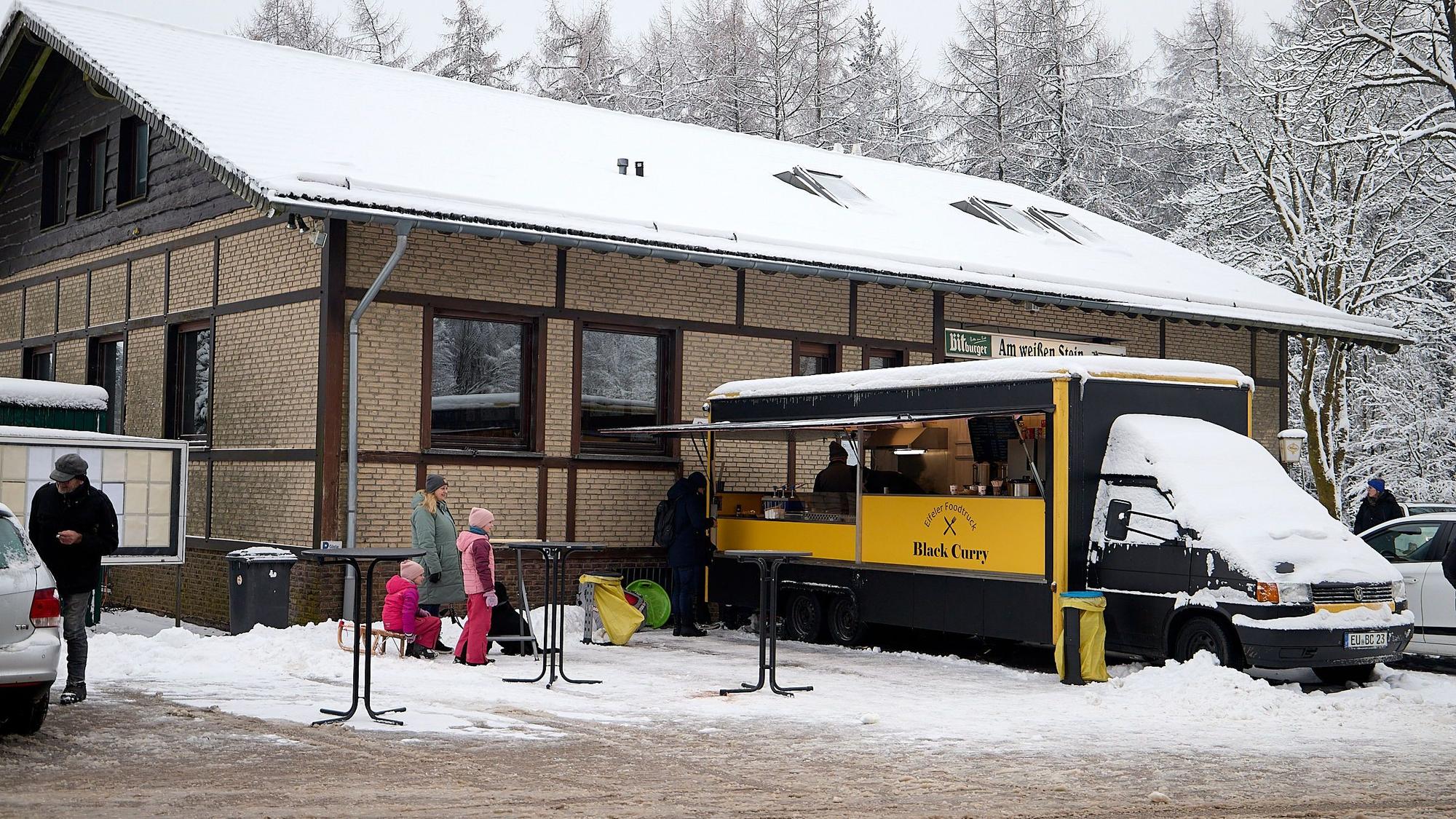 Der Imbisswagen steht vor dem Eingang des Restaurants bereit für hungrige Besucher.