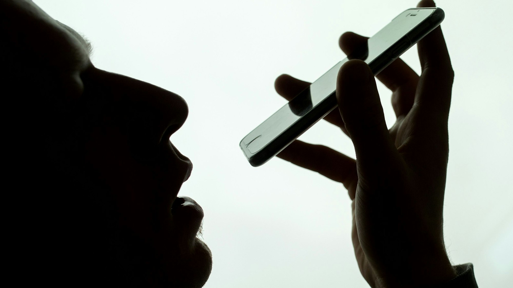 Ein Mann spricht in sein iPhone. Im Rechtsstreit um das mutmaßliche Mithören von Privatgesprächen seiner Nutzer durch seinen Sprachassistenten Siri hat Apple einer Zahlung von 95 Millionen Dollar (92 Millionen Euro) zugestimmt. (Symbolbild)