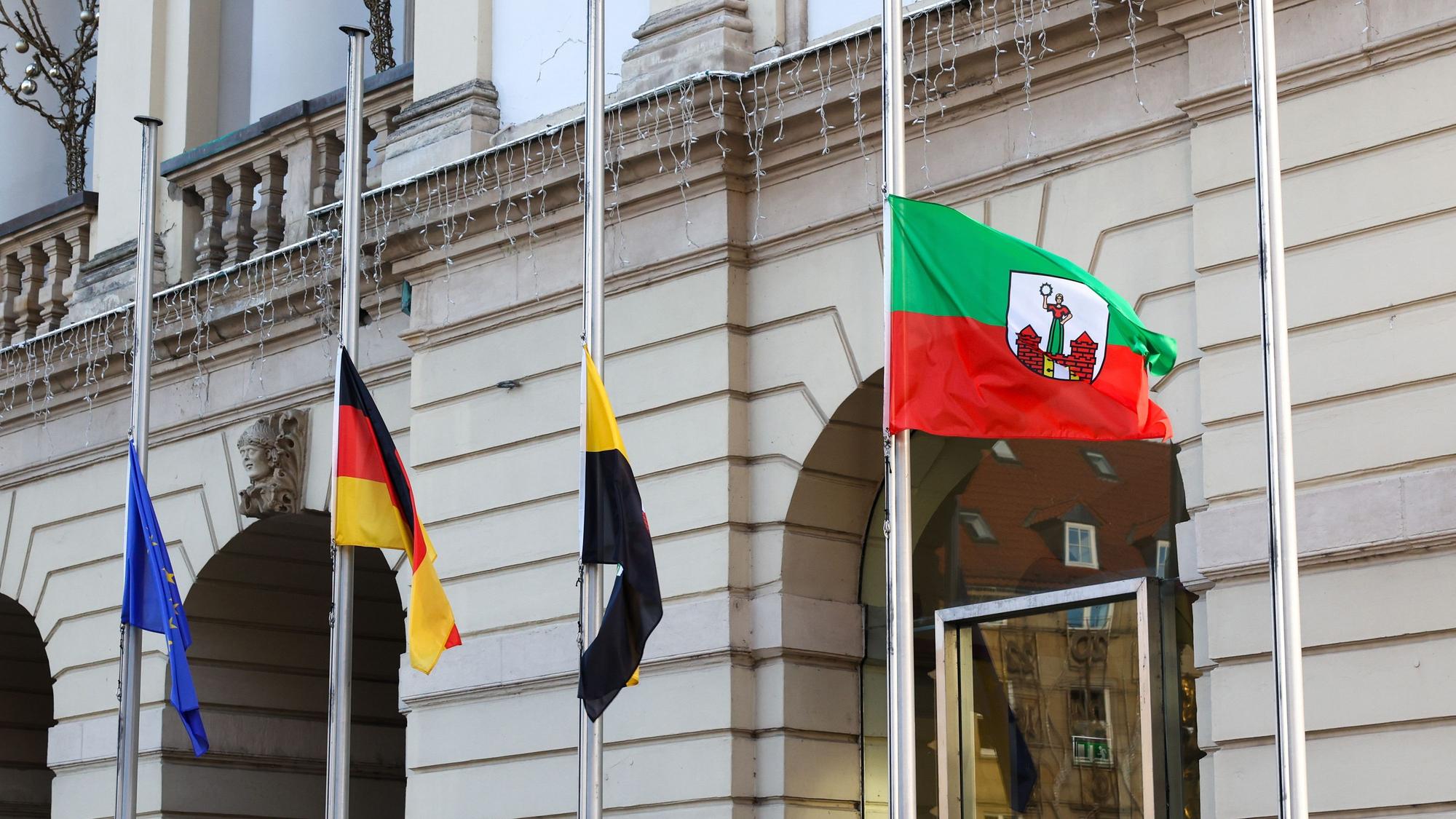Fahnen wehen vor dem Magdeburger Rathaus auf Halbmast.