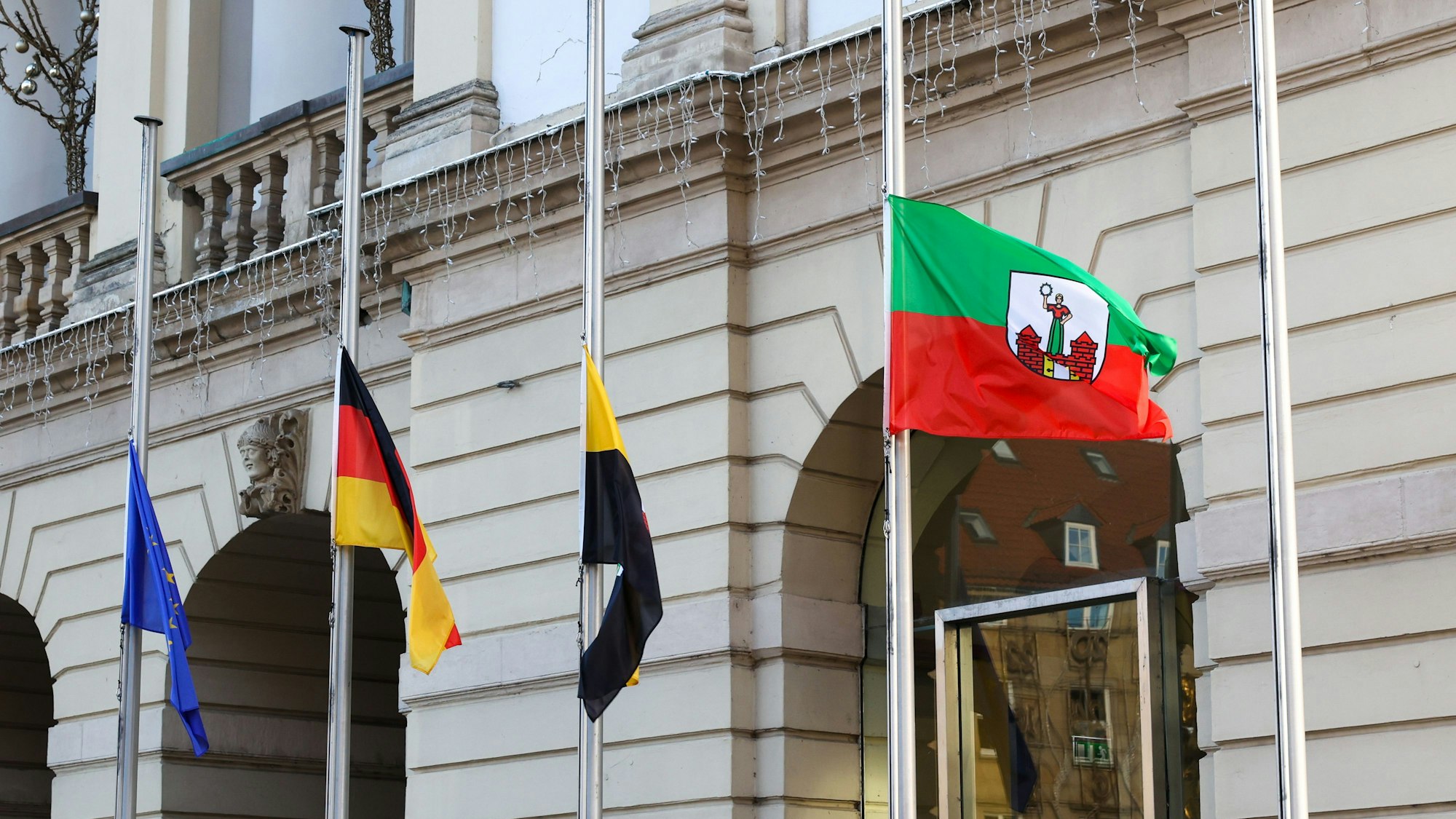 Fahnen wehen vor dem Magdeburger Rathaus auf Halbmast.
