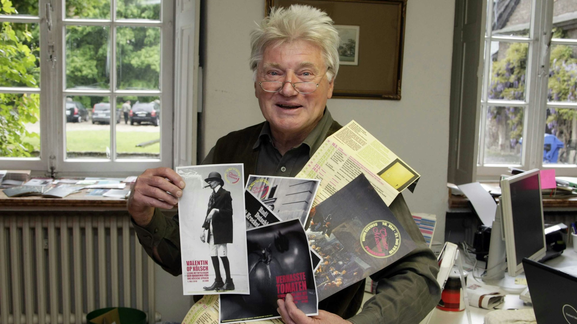 Elmar Buck hält verschiedene Bilder in der Hand