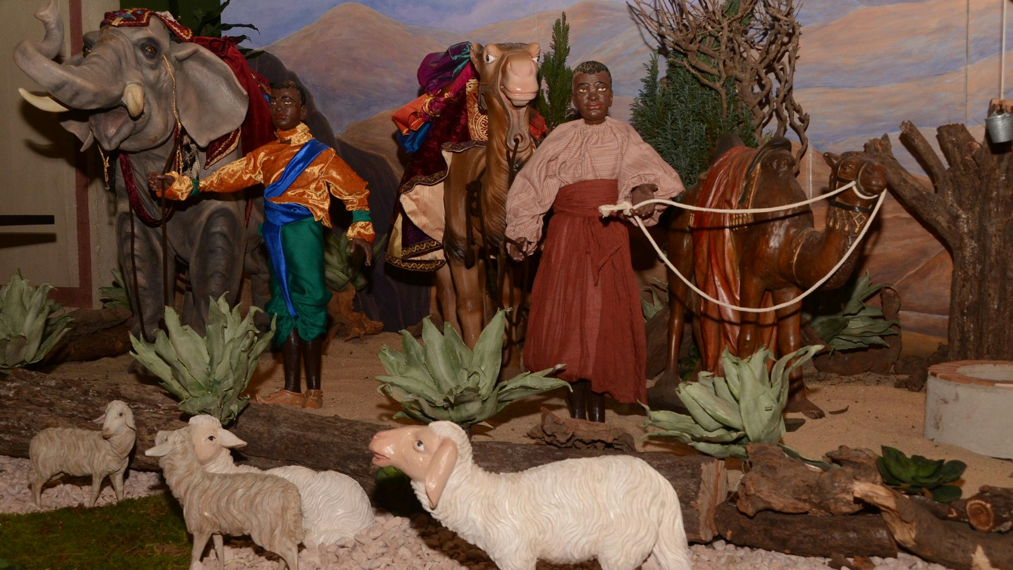 Eine Szenerie mit Tierfiguren und kleinen Puppen dunkelhäutiger Menschen.