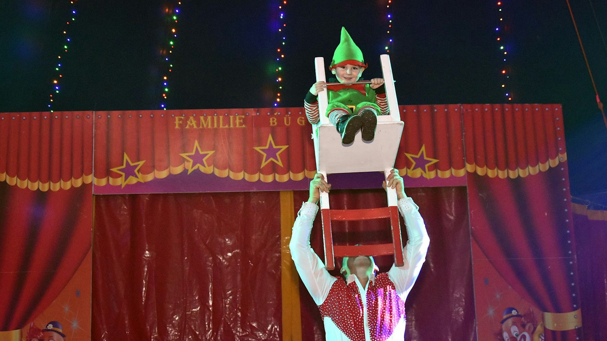 Angelo balanciert in der Zirkusmanege Giodano auf einem Stuhl.