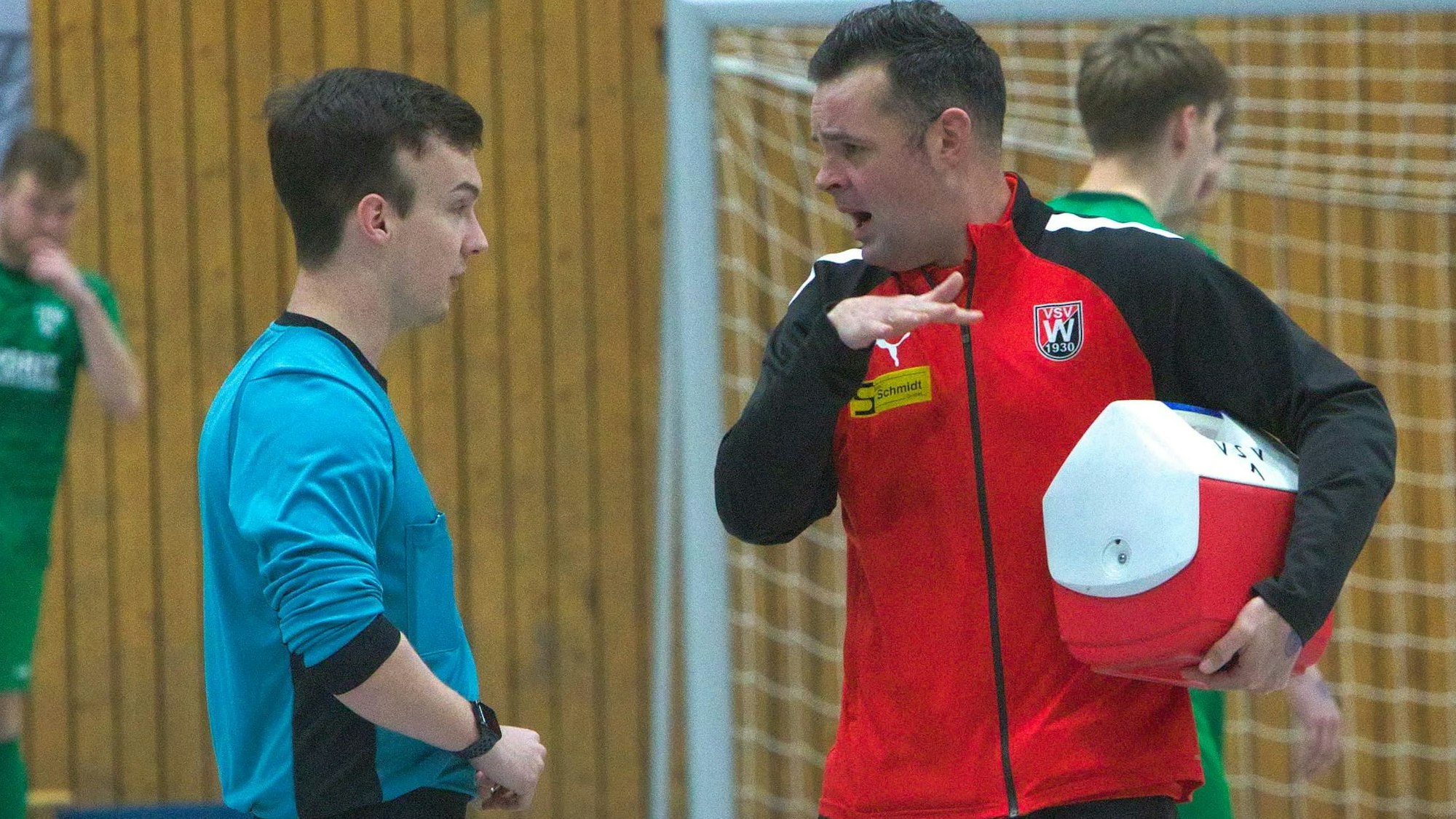 Ein Fußball-Trainer spricht mit einem Schiedsrichter.