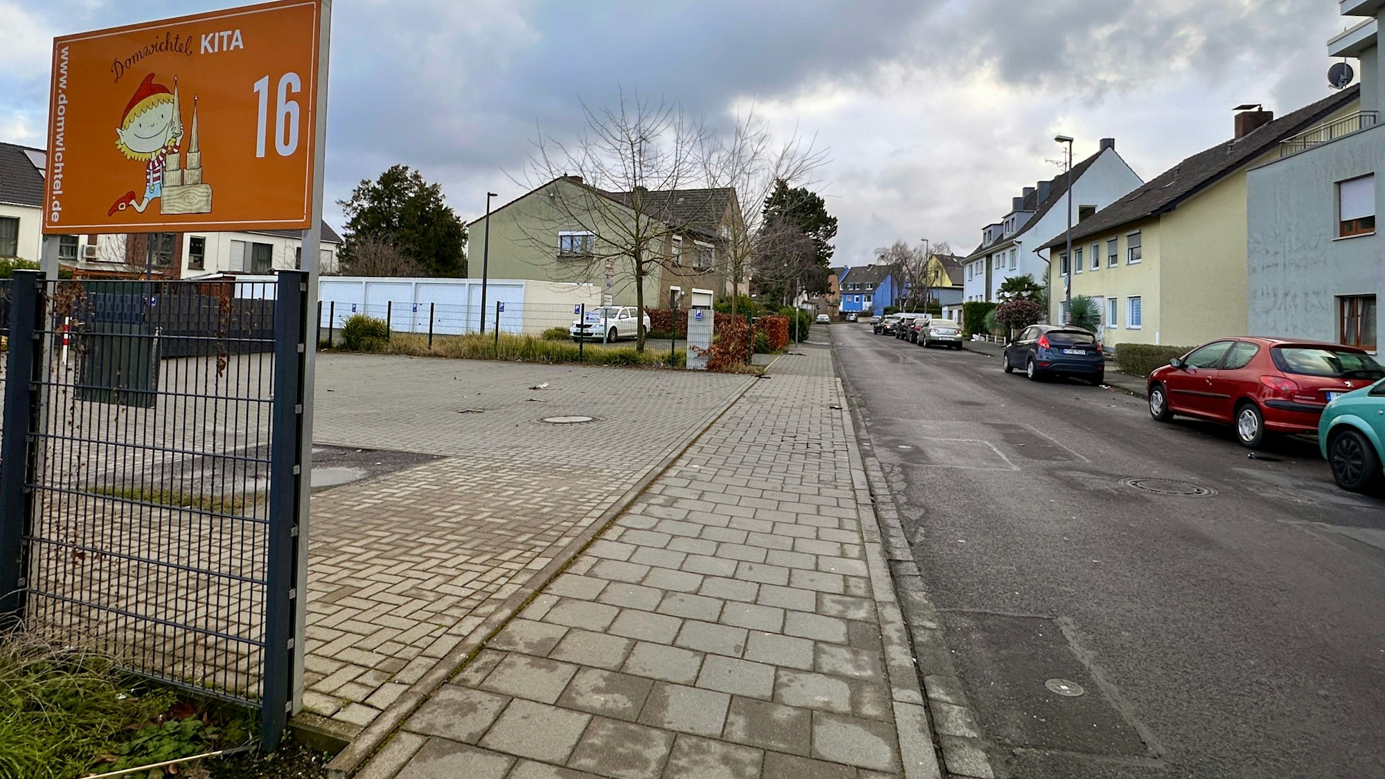 Das Schild einer Kita prangt auf einem Zaun am Vorplatz einer Kita.