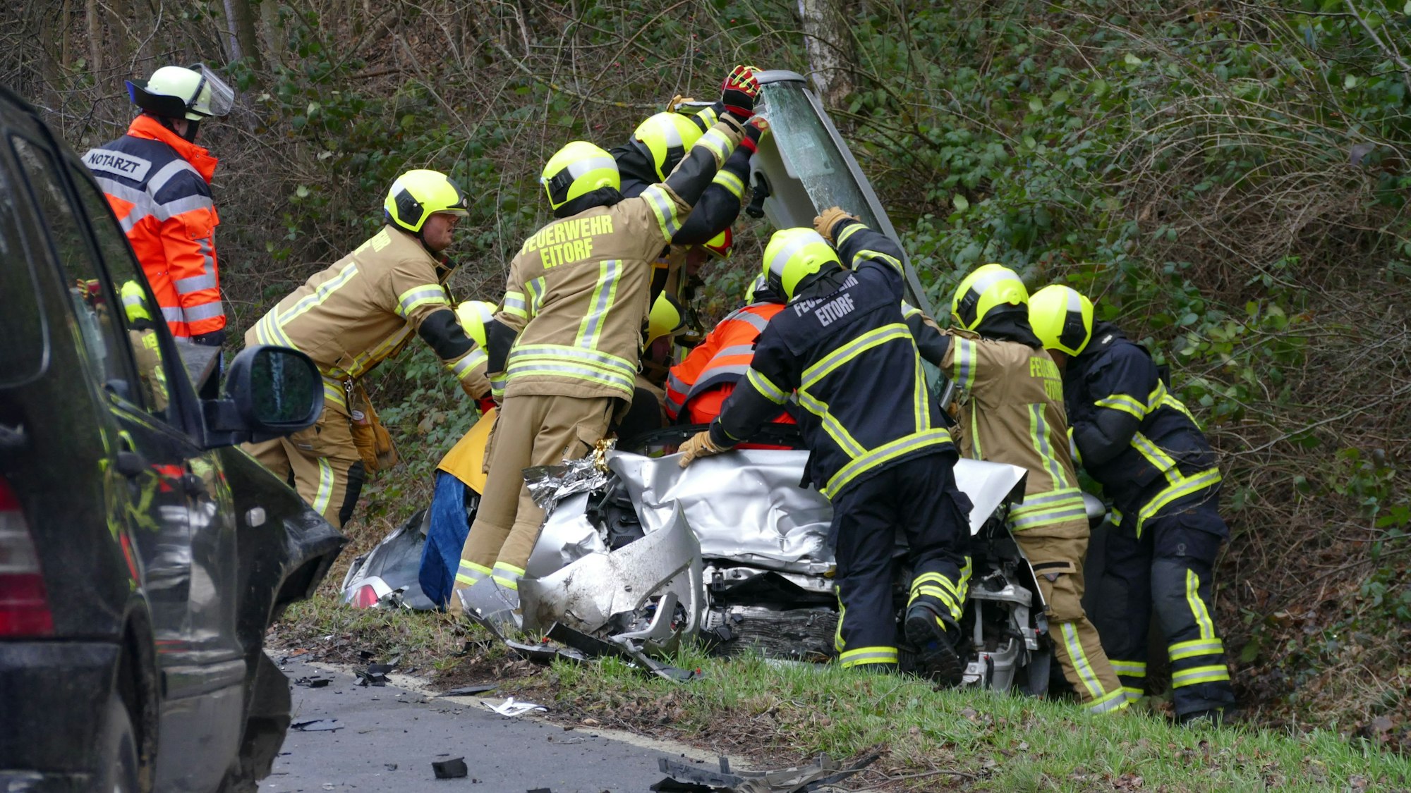 Feuerwehrleute schneiden das Dach des Opels weg, um den Mann zu erreichen.