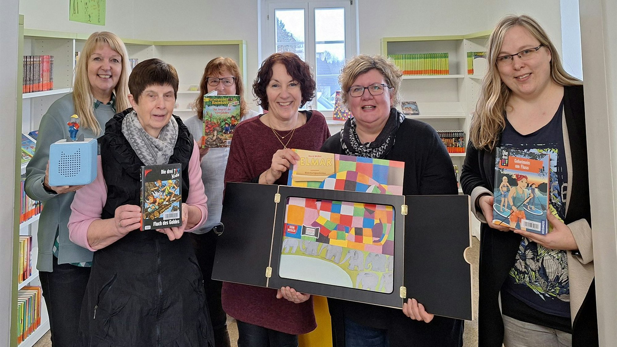 Doris Hilger, Irmgard Manderfeld, Silvia Müller, Andrea Niebes, Judith Keuer und Ingrid Koll zeigen Bücher und Spiele.
