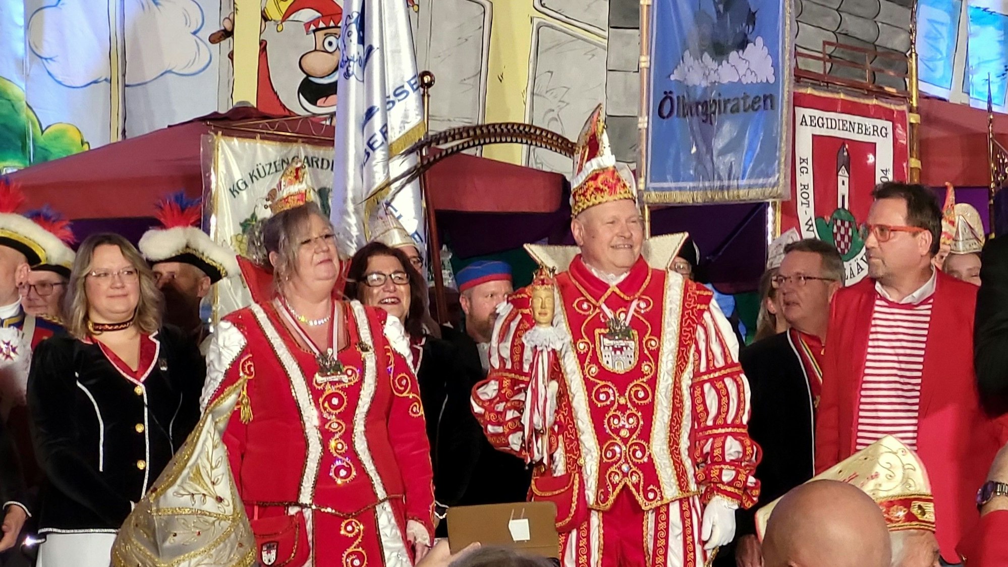 Ein Karnevalsprinzenpaar und Gefolge stehen auf einer Bühne.