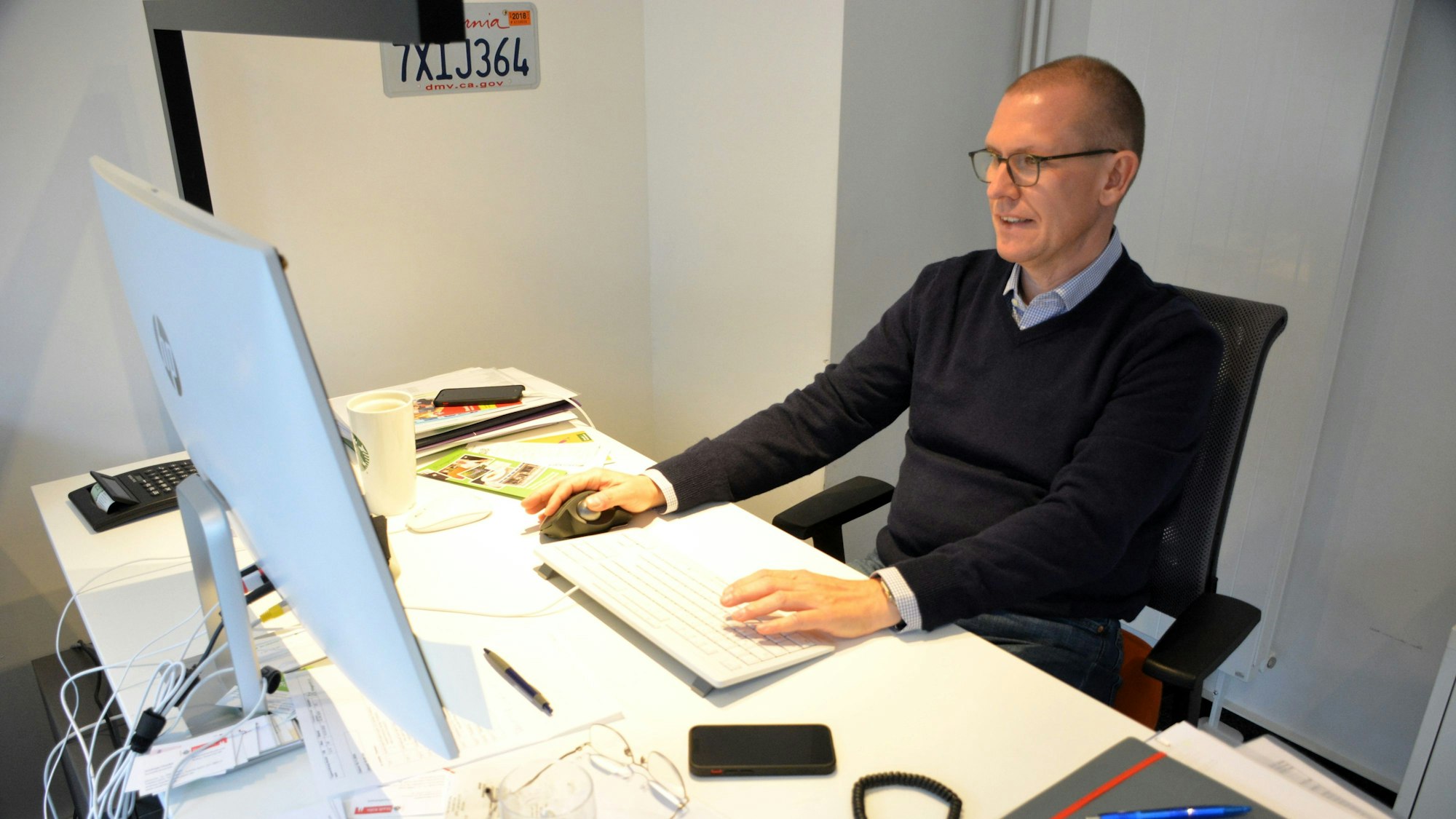 Ein Mann sitzt an einem Schreibtisch.