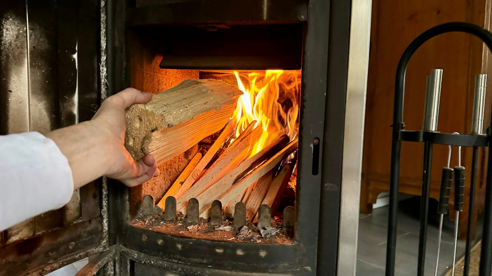Ein alter Kaminofen wird angezündet.