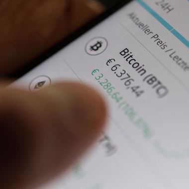 ILLUSTRATION - Eine Frau bedient die App "Bison" der Börse Stuttgart, mit der Kryptowährungen wie Bitcoin, Ethereum, Litecoin und Ripple über ein Smartphone gekauft und verkauft werden können. (zu dpa "Pressekonferenz der Börse Stuttgart zu Abschluss des Börsenjahres 2019") +++ dpa-Bildfunk +++