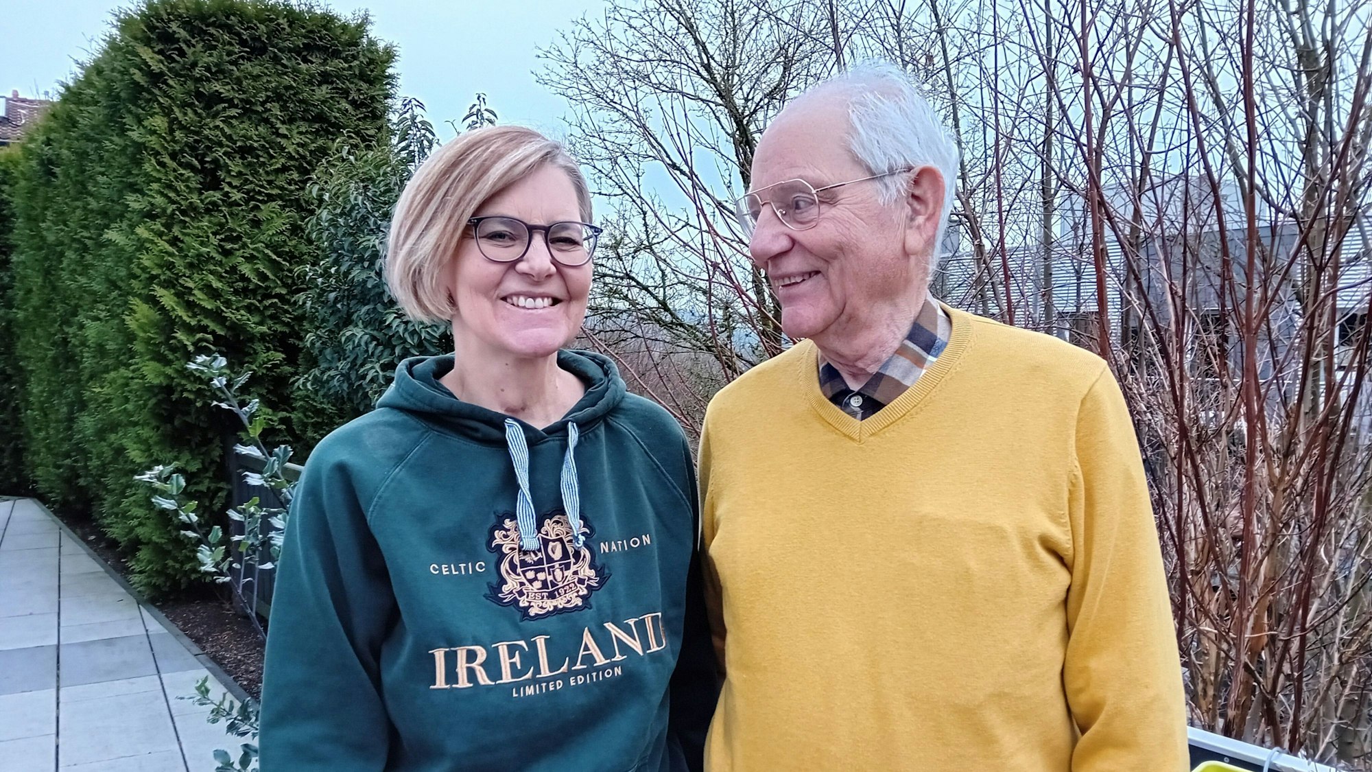 Ein älterer Herr blickt auf eine jüngere Frau.