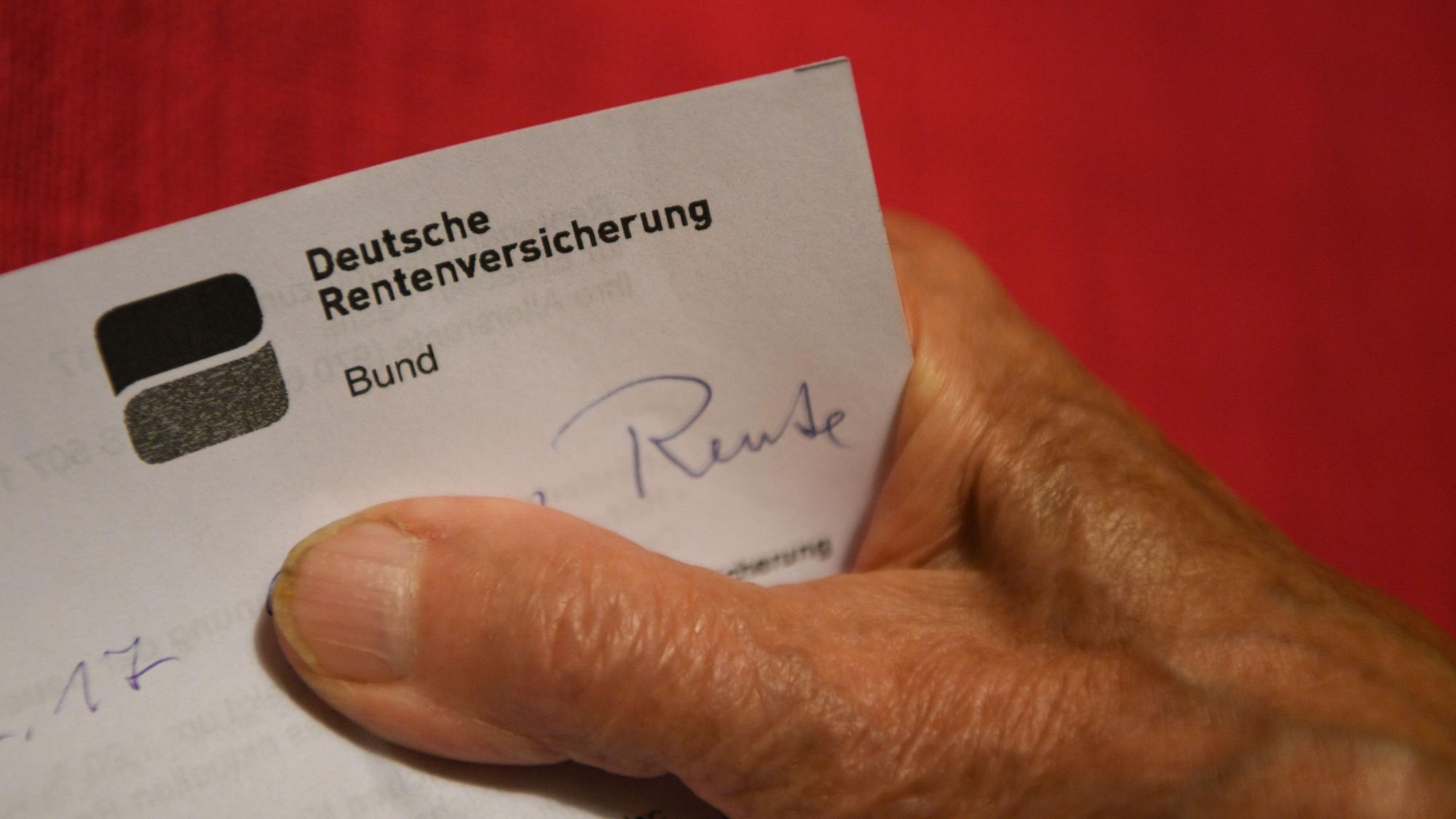 Eine ältere Frau hält ihren Rentenbescheid in der Hand (gestellte Szene).