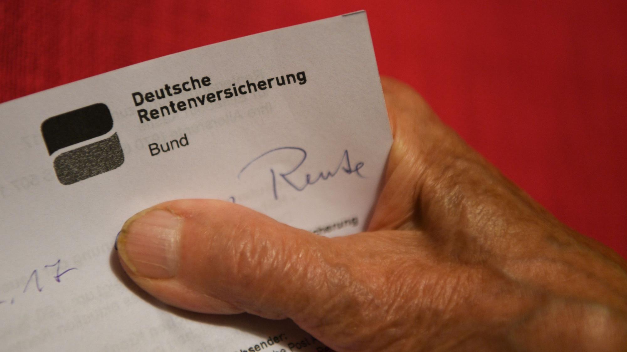 Eine ältere Frau hält ihren Rentenbescheid in der Hand (gestellte Szene).