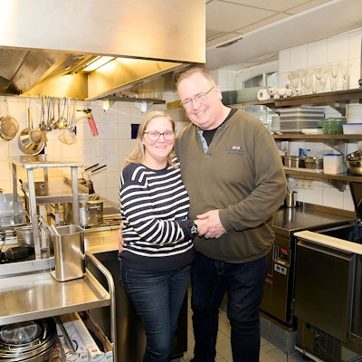 Bianka und Harald Paulus, die Betreiber des Schlossrestaurants in Schleiden, stehen Arm in Arm in der Küche ihres Restaurants.