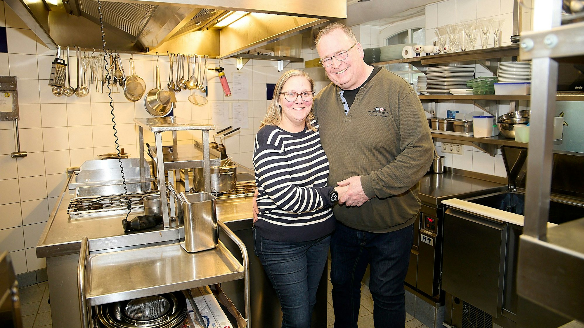 Bianka und Harald Paulus, die Betreiber des Schlossrestaurants in Schleiden, stehen Arm in Arm in der Küche ihres Restaurants.