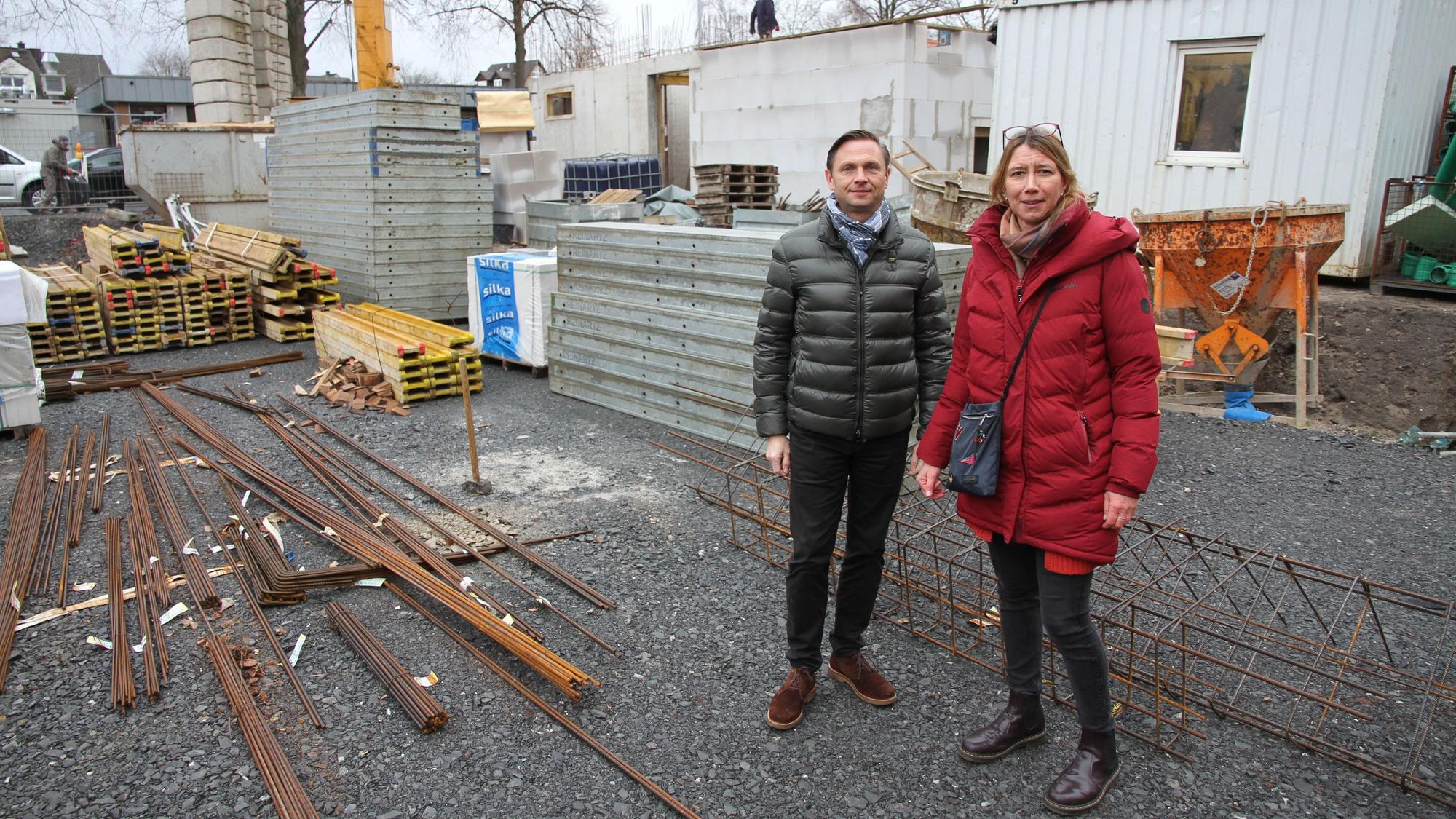Ein Mann und eine Frau in Winterjacken auf einer Baustelle
