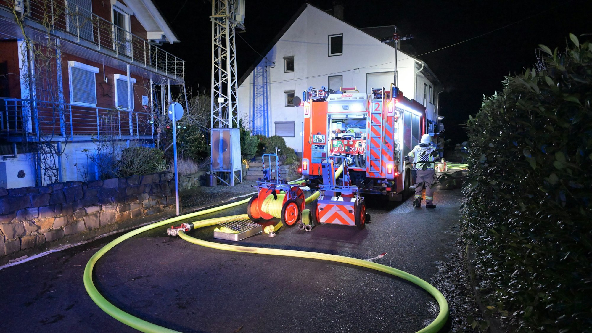 Ein Feuerwehrfahrzeug steht vor einem Haus in Bergisch Gladbach-Voislöhe.