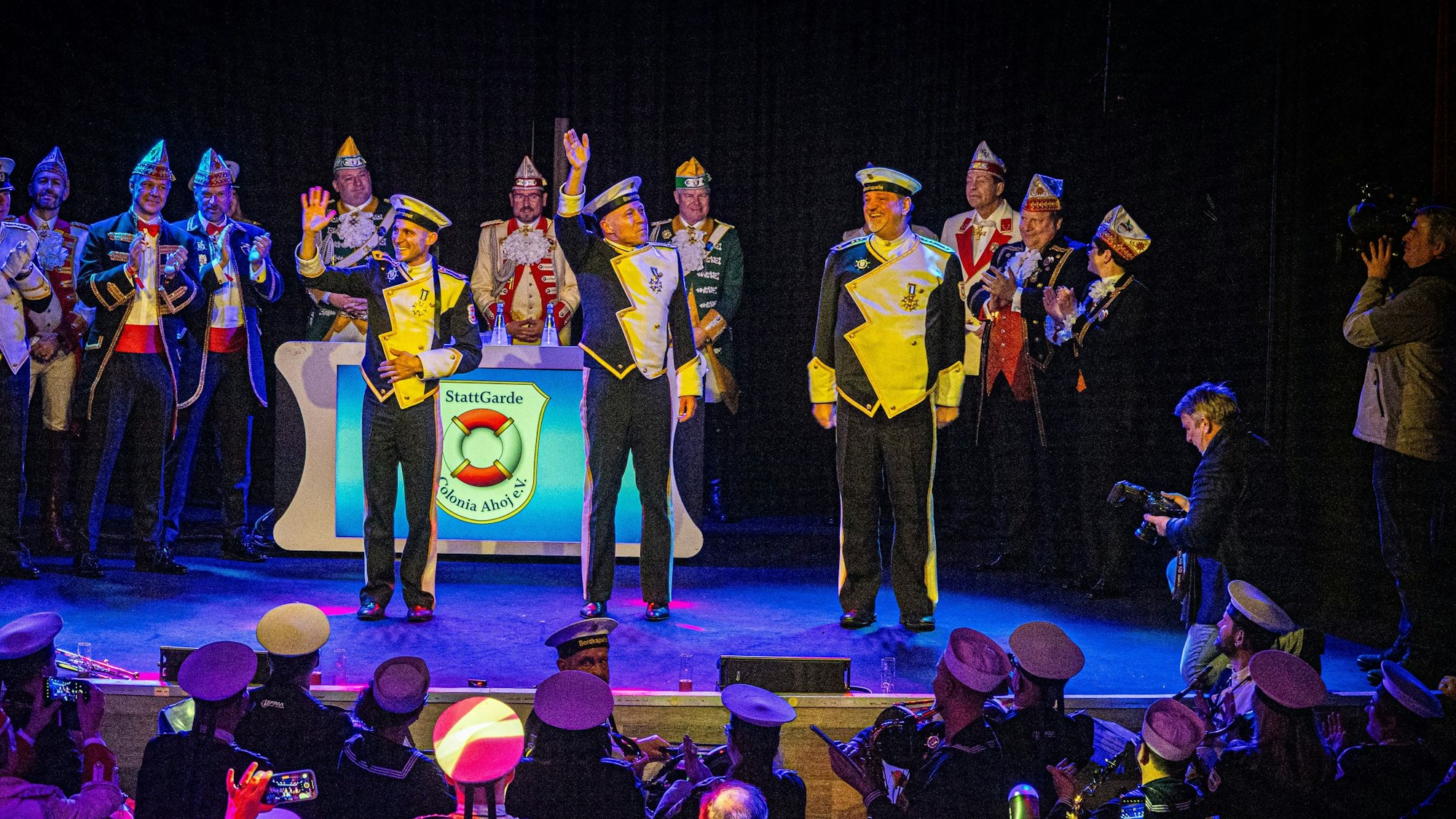 Gruß auf dem Schiff an die mitfahrenden Gardisten: Prinz René I. (M.), Bauer Michael (r.) und Jungfrau Marlis (l.)