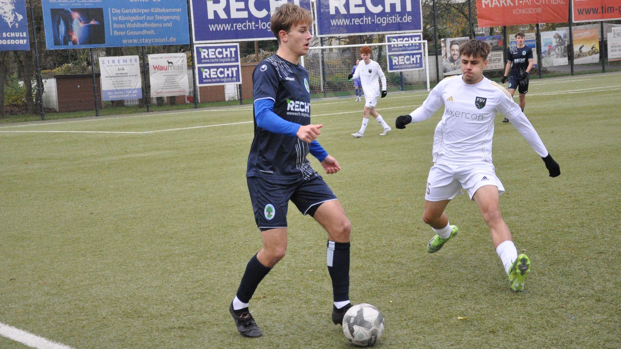 Das Bild zeigt einen Spieler im blauen Trikot, der den Ball vor seinem Gegner im weißen Dress dem Ball behauptet.