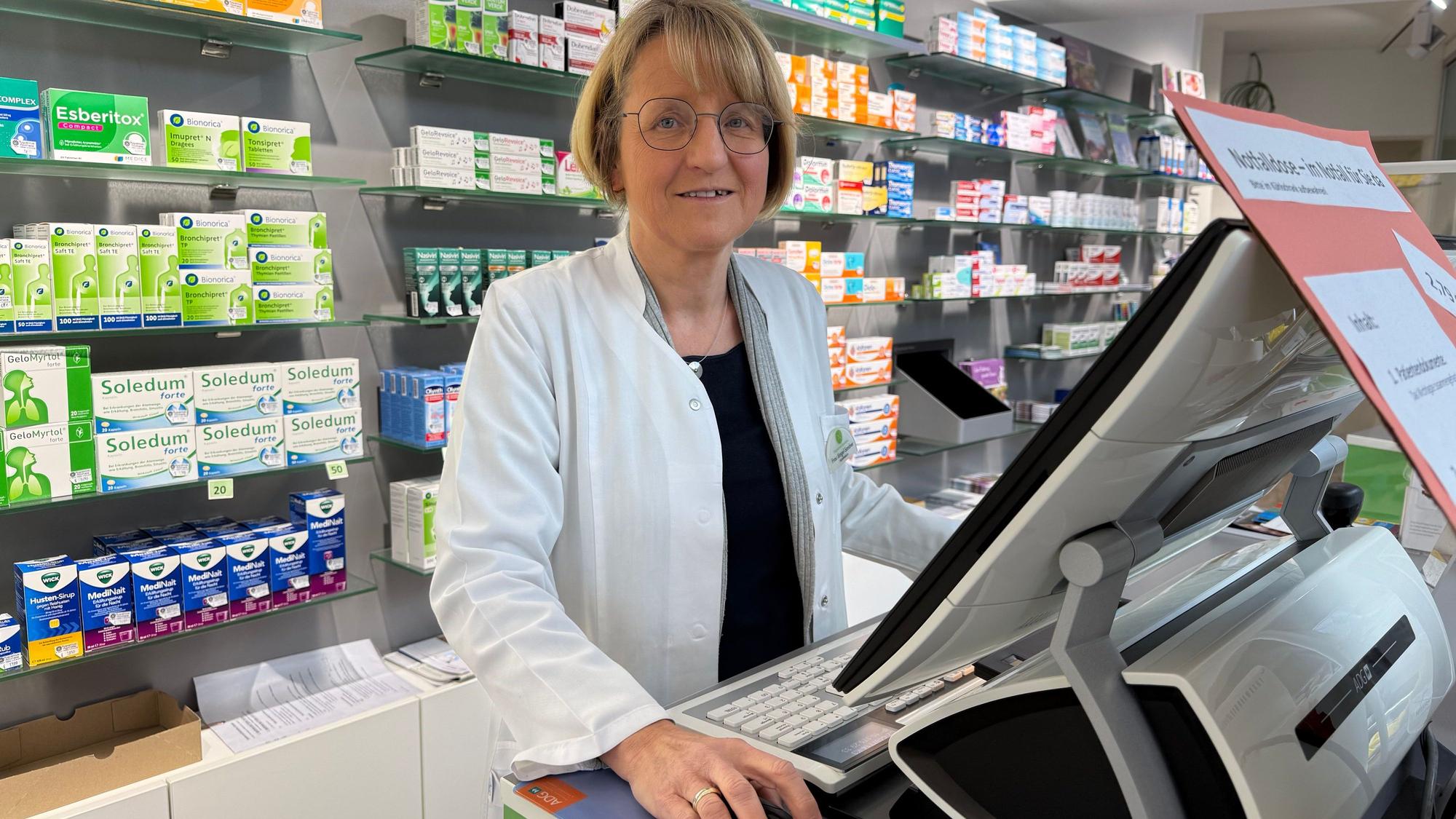 Eine Apothekerin hinter ihrer Kasse.