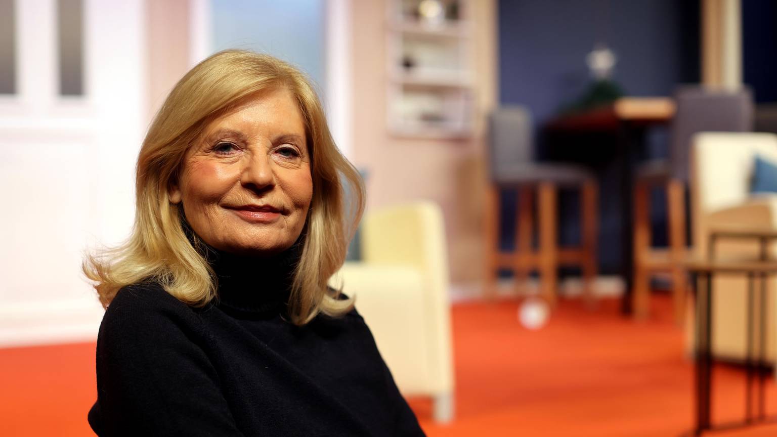 Sabine Postel sitzt auf einem Stuhl im Theater am Dom.