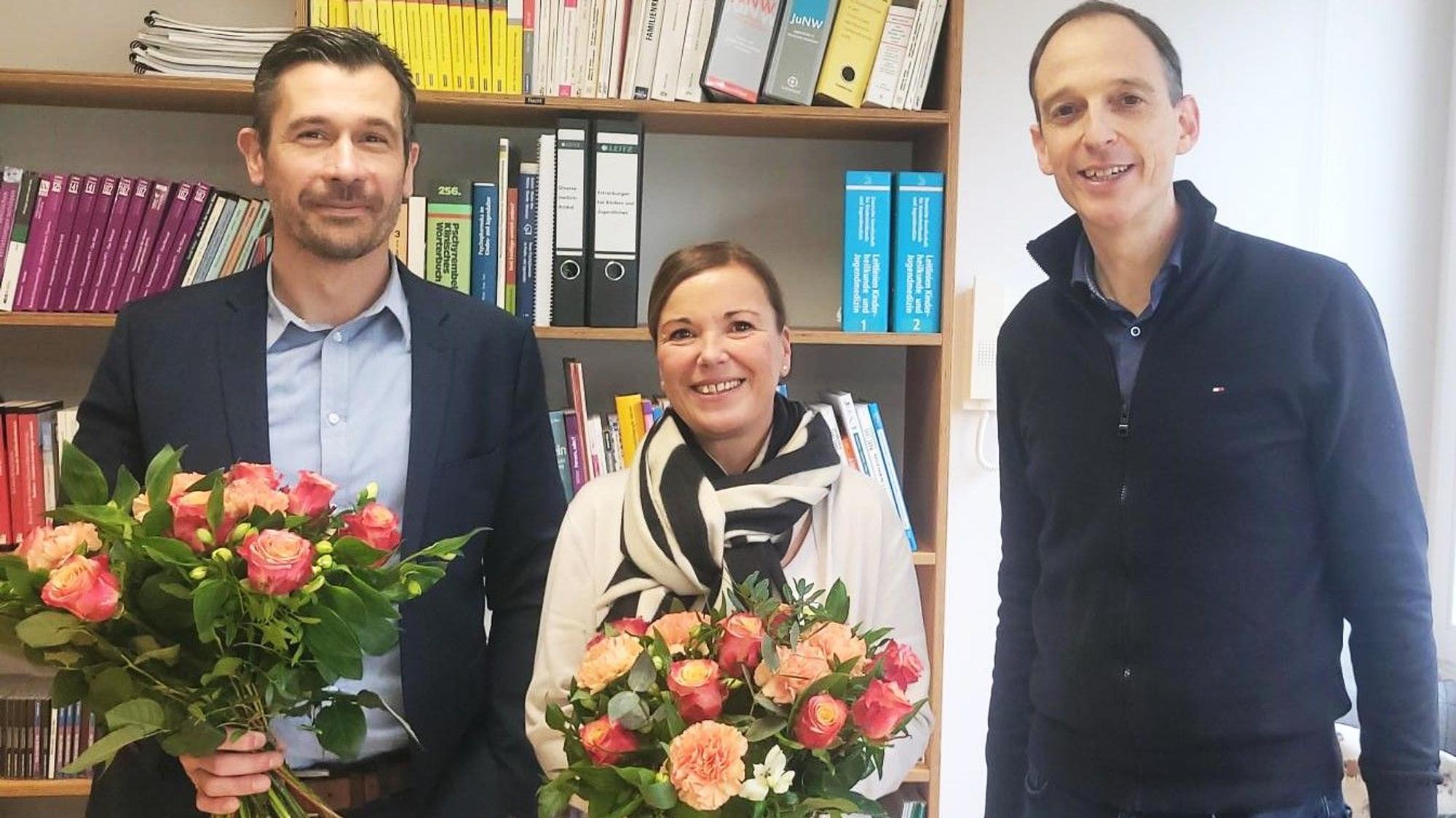 Maik Nohles (l.) und Ulrike Reinartz halten je einen Blumenstrauß. Denis Thelen steht daneben.