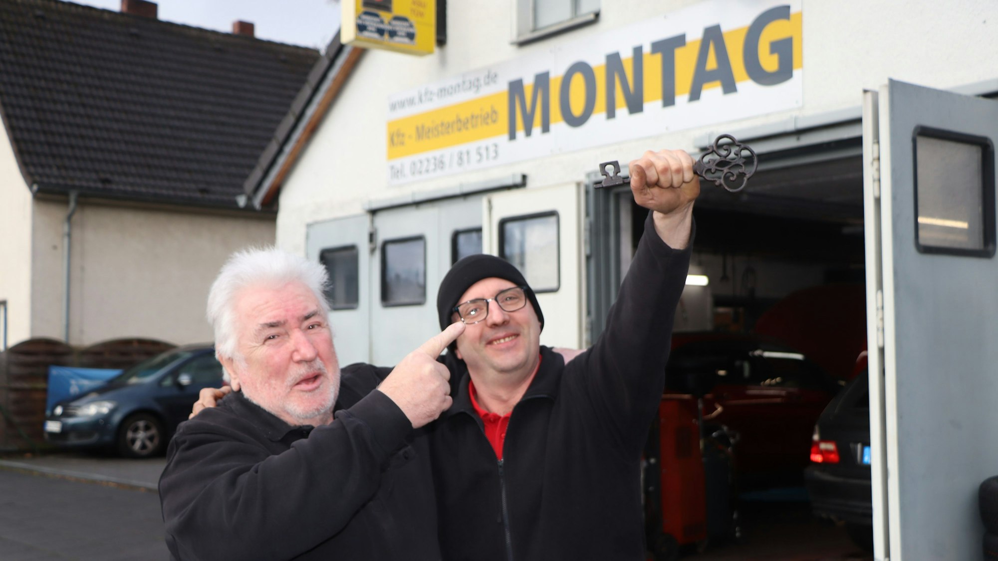Das Foto zeigt Vater Alfred Montag und seinen Sohn vor der Werkstatt bei der Betriebsüergabe.