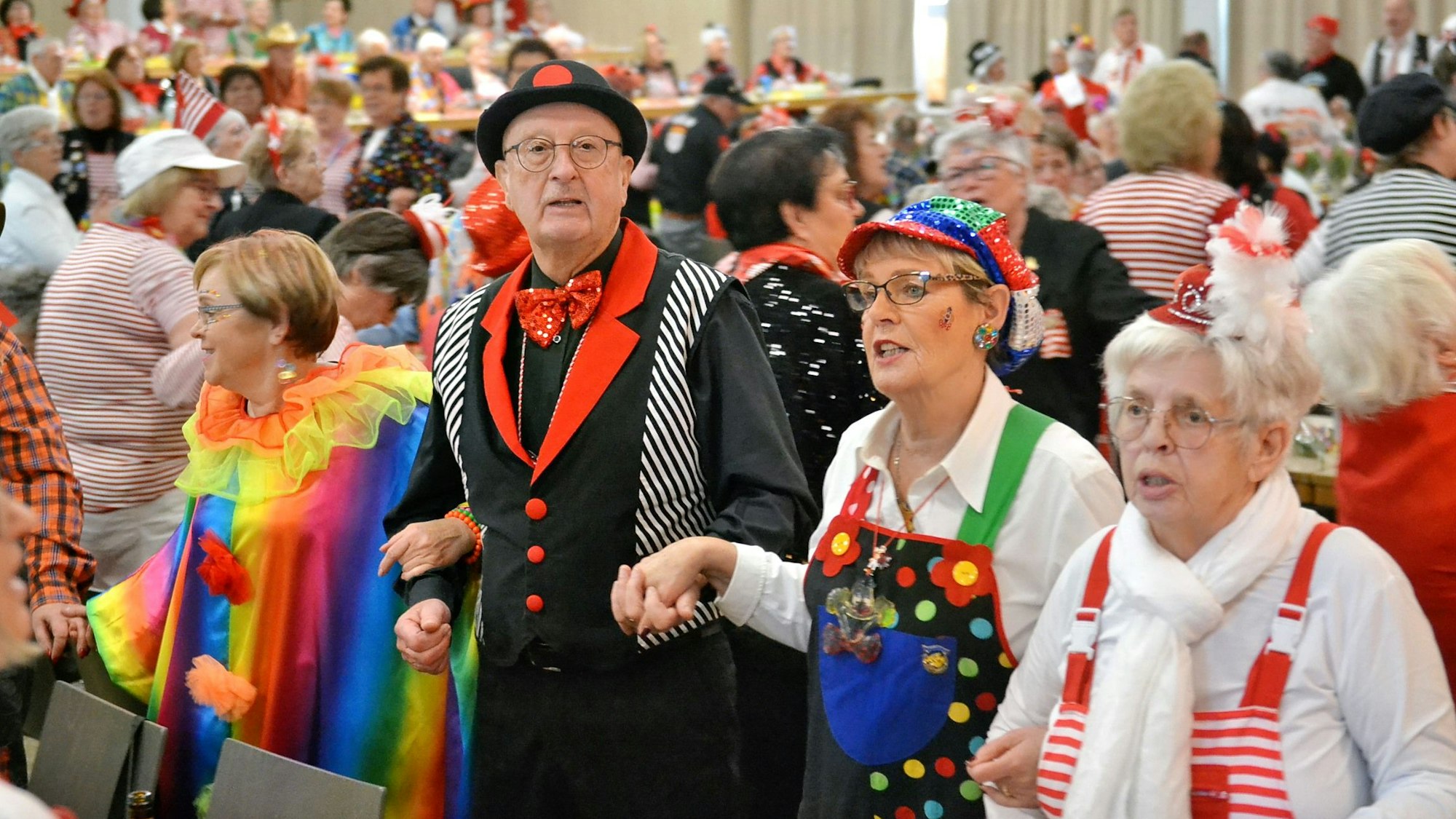 Das Bild zeigt mehrere kostümierte Besucher, die schunkeln.