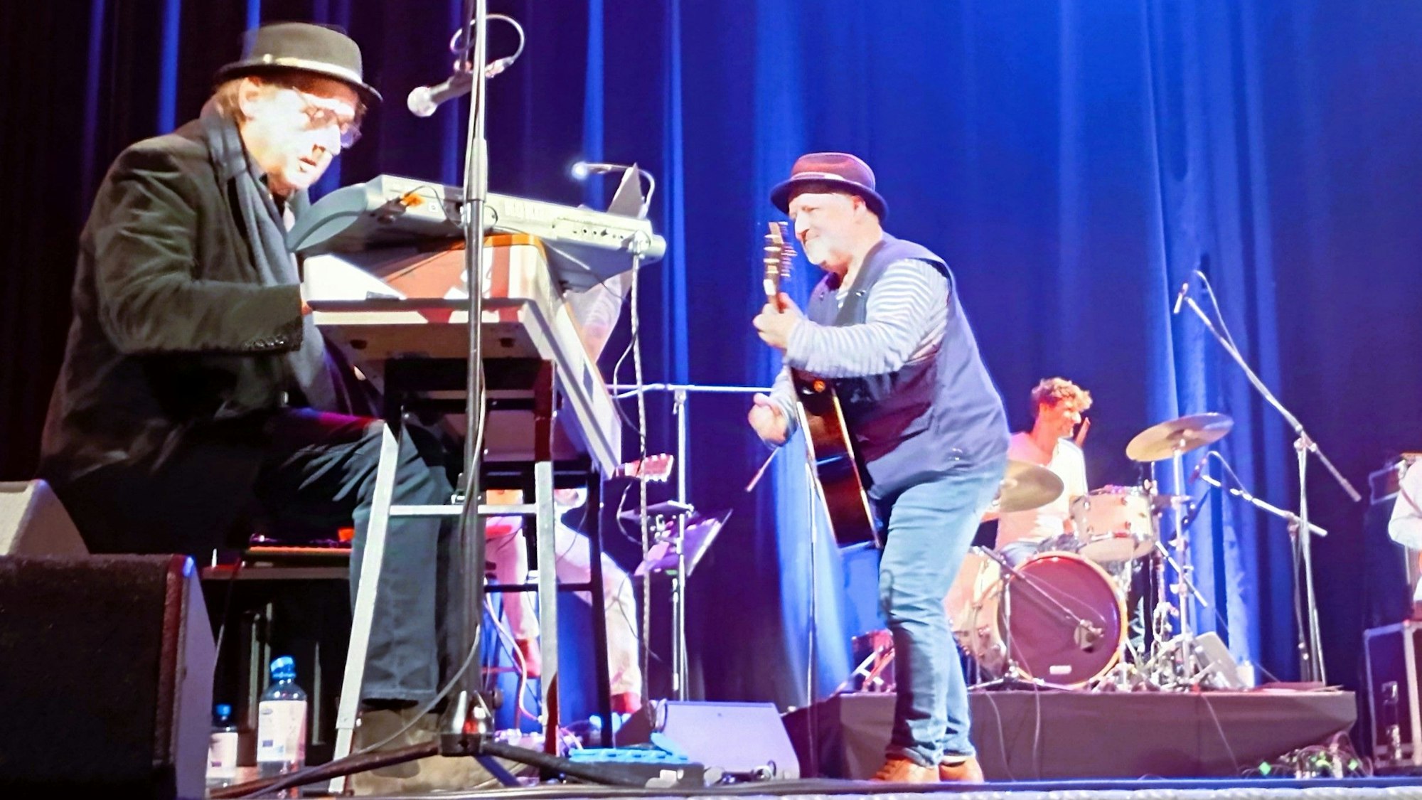 Auf dem Bild sind Musiker auf einer Bühne zu sehen.