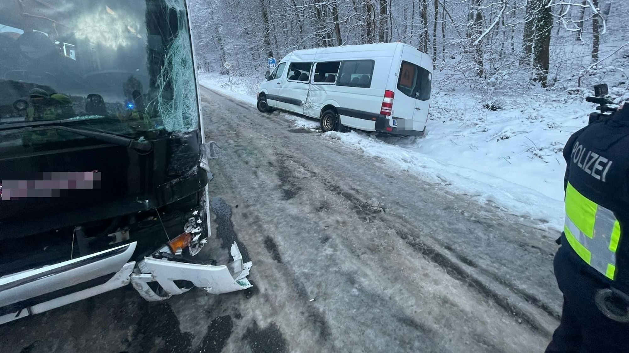 Ein weißer Kleinbus steht in einem verschneiten Straßengraben.