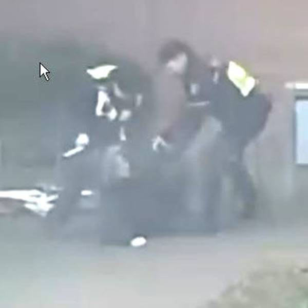 Das Bild ist ein Ausschnitt aus einer Videoaufnahme und zeigt zwei Polizisten, die auf eine Person einschlagen.