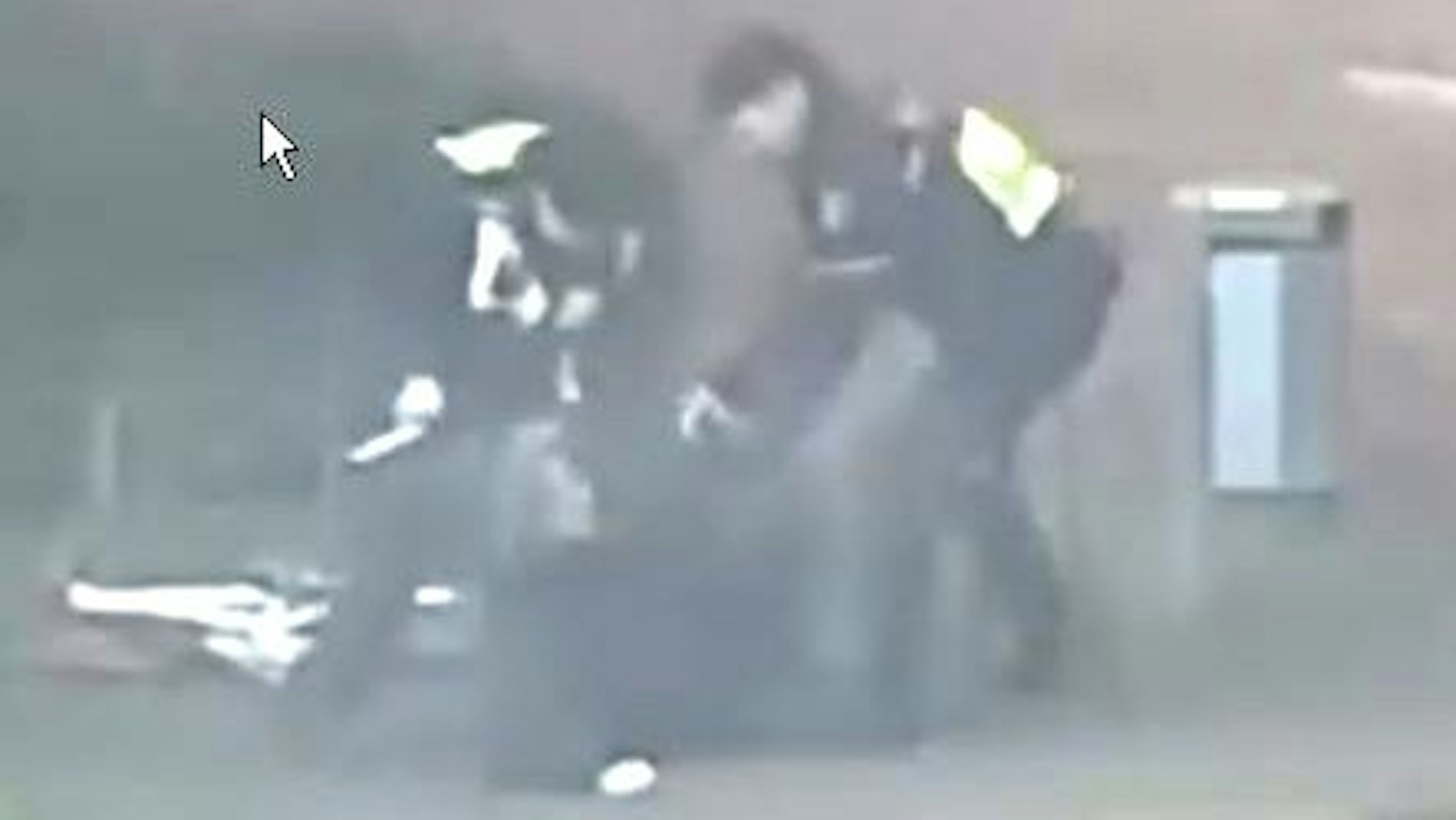 Das Bild ist ein Ausschnitt aus einer Videoaufnahme und zeigt zwei Polizisten, die auf eine Person einschlagen.