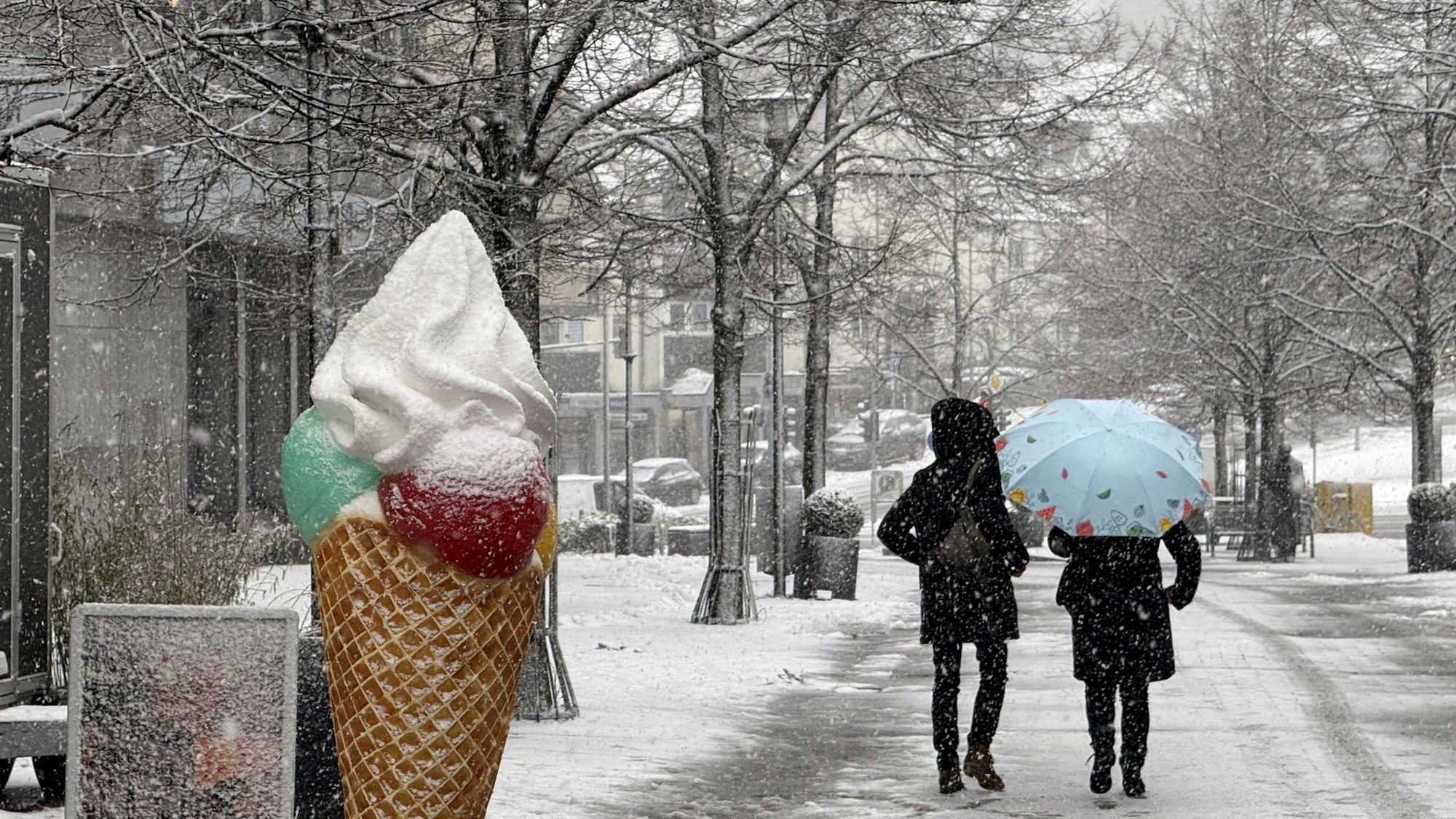 Ein großes, eingeschneites Eishörnchen in einer Fußgängerzone.