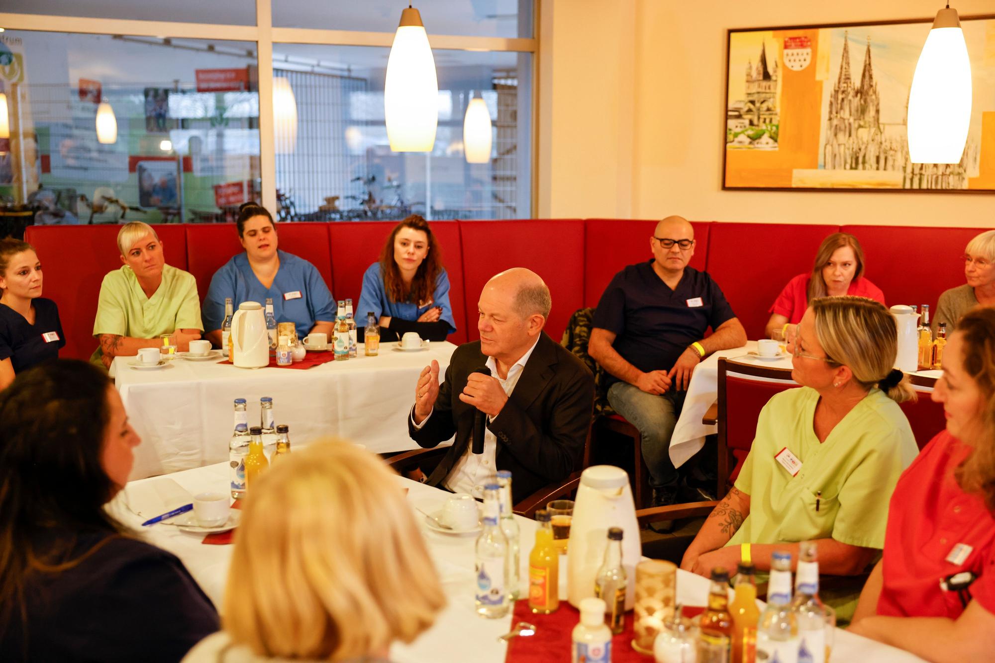 Bundeskanzler Olaf Scholz im Gespräch mit Pflegekräften des Awo-Seniorenzentrums in Köln-Chorweiler.