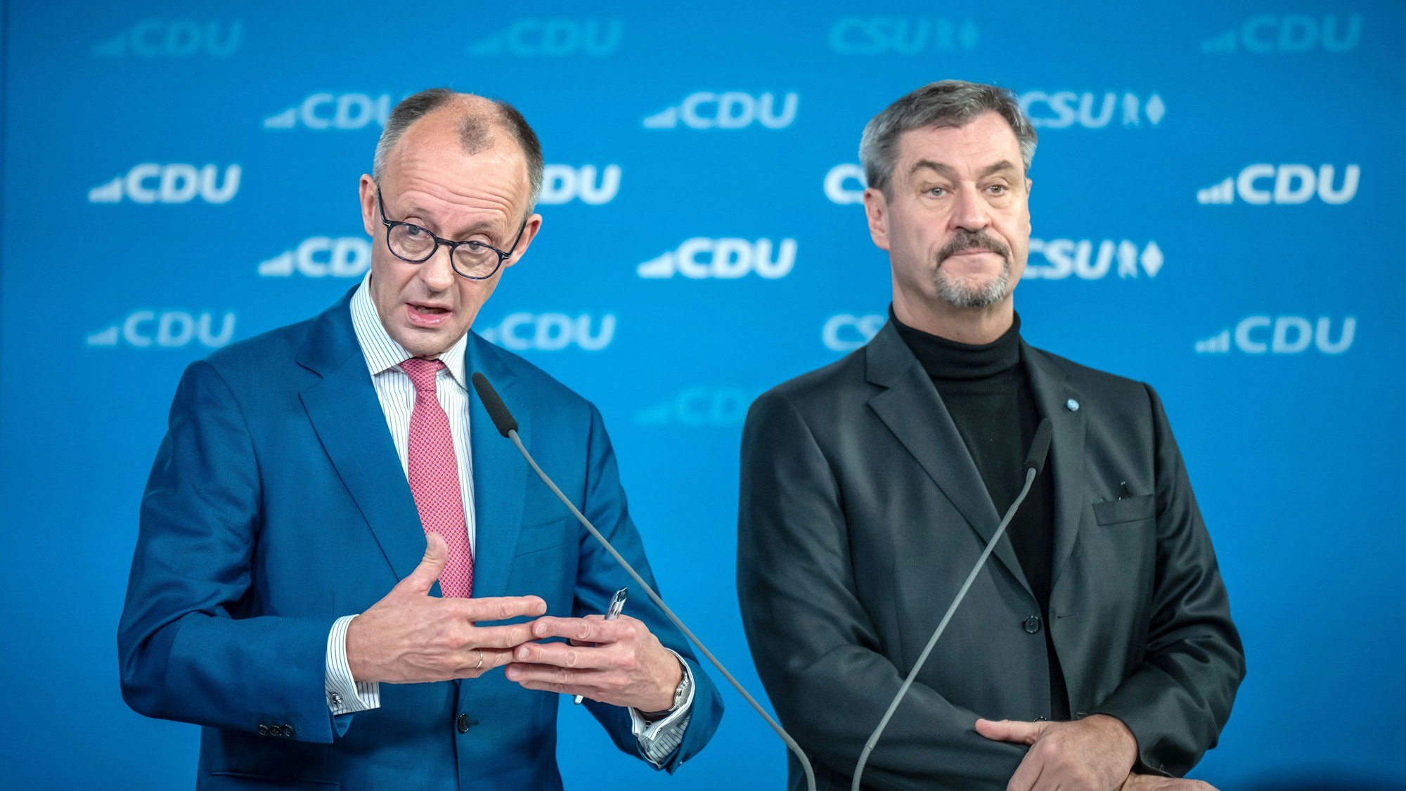17.12.2024, Berlin: Friedrich Merz (l), CDU-Bundesvorsitzender und CDU/CSU-Fraktionsvorsitzender im Bundestag, spricht neben Markus Söder, (CSU), Ministerpräsident von Bayern und CSU-Vorsitzender, bei der Vorstellung des gemeinsamen Wahlprogramms für die Bundestagswahl 2025 nach der Sitzung der Vorstände von CDU und CSU. Foto: Michael Kappeler/dpa +++ dpa-Bildfunk +++