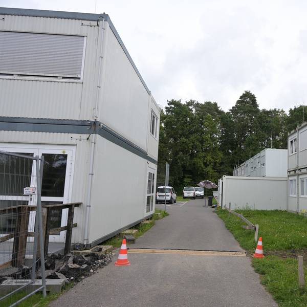 Zwischen zwei zweistöckigen Containerblöcken führt ein Weg.