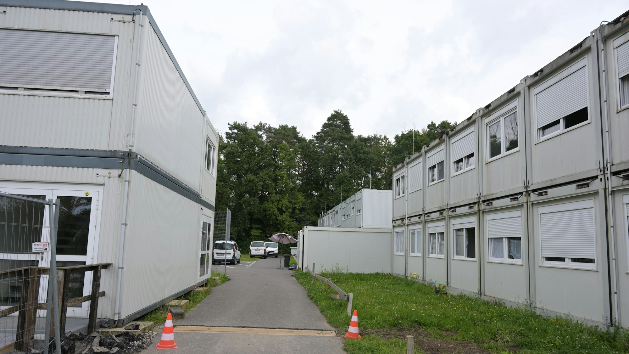 Zwischen zwei zweistöckigen Containerblöcken führt ein Weg.