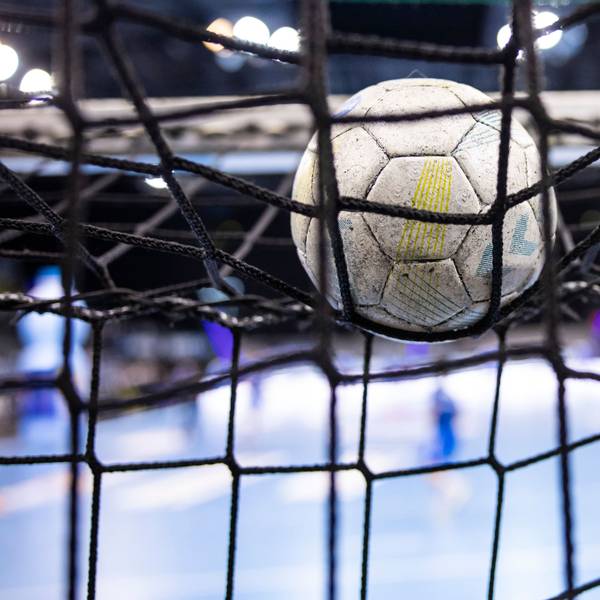 Ein Handball im Netz eines Tores.