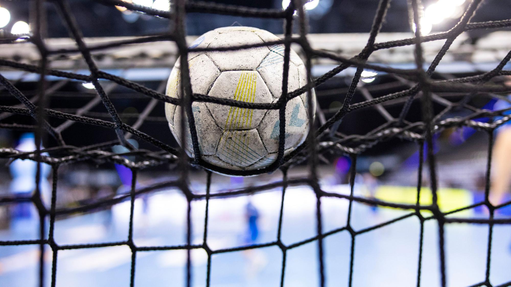 Ein Handball im Netz eines Tores.