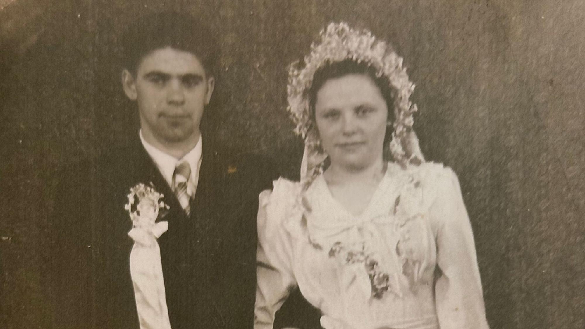 Schwarzweiß-Foto eines jungen Hochzeitspaars.